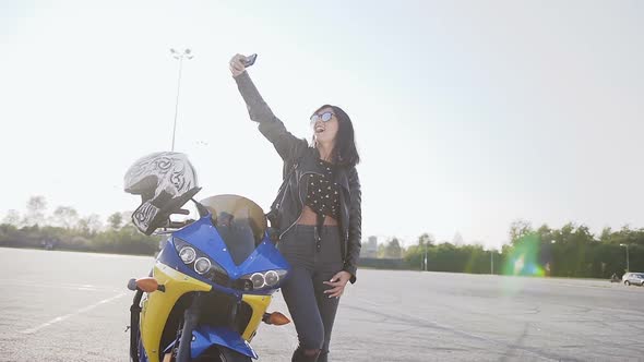 Biker Girl Stands next to Her Yellow and Blue Motorcycle
