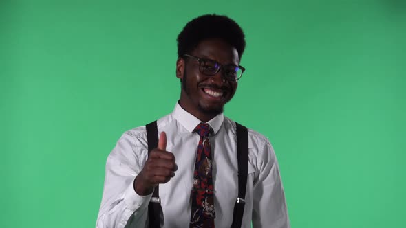 Portrait of Young African American Man Looking at Camera Smiling and Showing Thumbs Up Gesture
