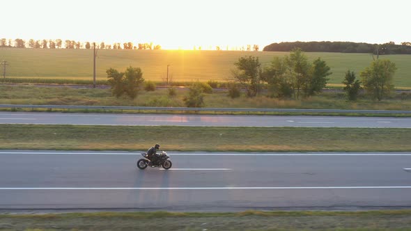 Aerial View to Biker Rides on Modern Sport Motorbike at Highway