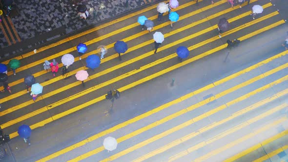 The messy of people are crossing the road in the rainy day of Hong Kong.