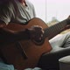 Young man singing and playing the guitar in back of campig van - VideoHive Item for Sale