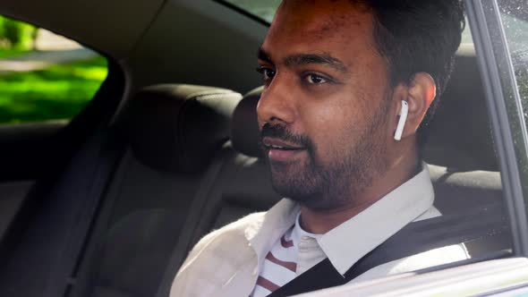 Indian Male Passenger with Earphones in Taxi Car