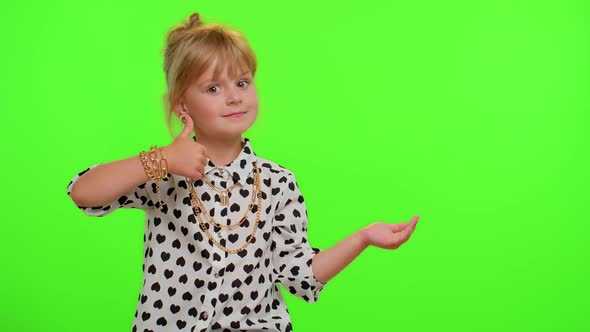 Funny Child Girl Showing Thumbs Up and Pointing Empty Place Advertising Area for Commercial Text