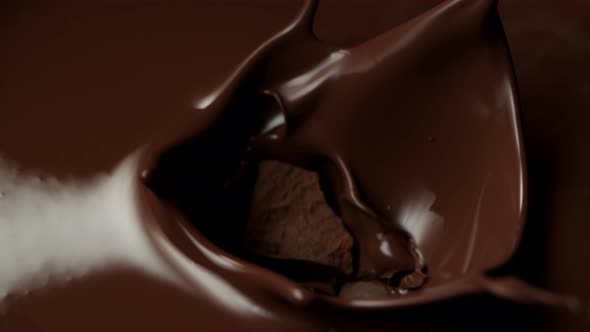 Super Slow Motion Shot of Raw Chocolate Chunks Falling Into Melted Chocolate at 1000Fps