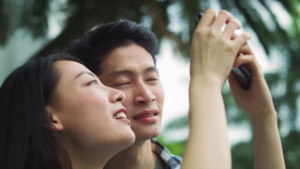 Handheld view of Vietnamese couple with mobile phone. Shot with RED helium camera in 8K