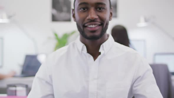 Portrait of smiling african american businessman looking at camera in modern office