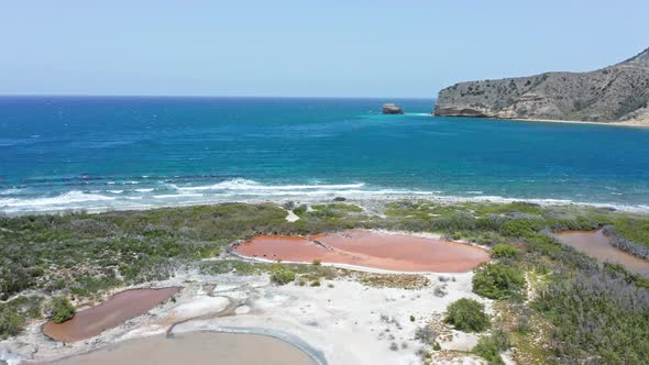 Isla Cabra coast with pink lagoon and Montecristi headland in background, Dominican Republic. Aerial