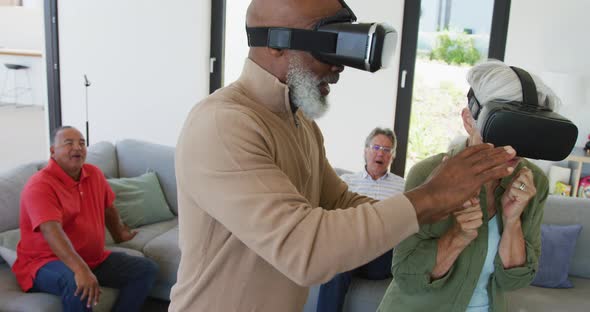 Happy senior diverse people using vr headsets at retirement home