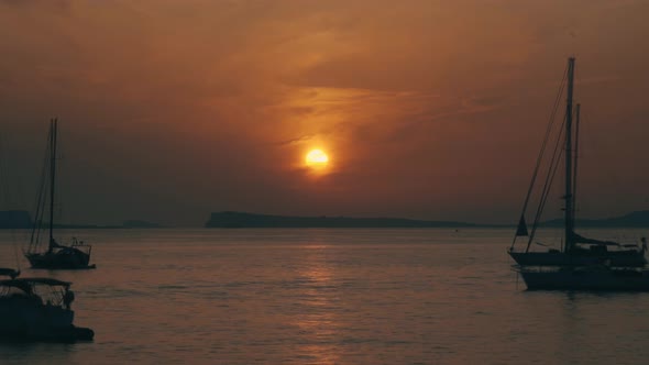 Sunset Timelapse by the Sea behind the Mountain Islands with Sailing Ships