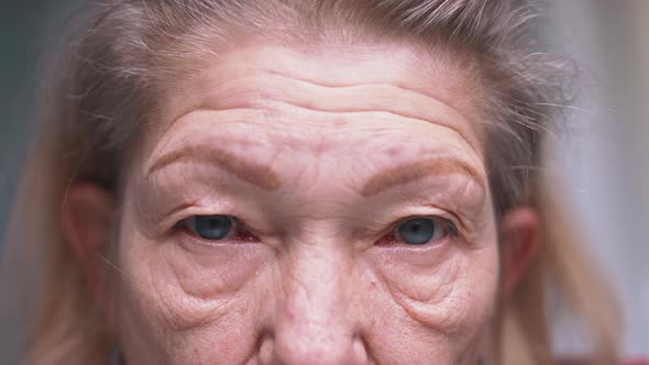 Close Up on Blue Eyes of an Elderly Woman with Wrinkled Skin