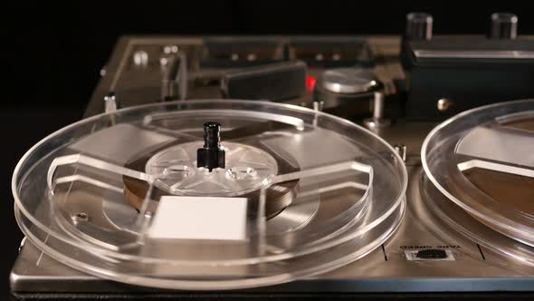 Vintage Reel to Reel tape recorder playing music close up of reel