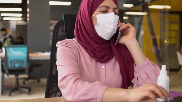 Modern Muslim Business Woman in Hijab Working in the Office and Talking on the Phone