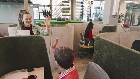 Happy Woman High-Fiving Colleagues in Office