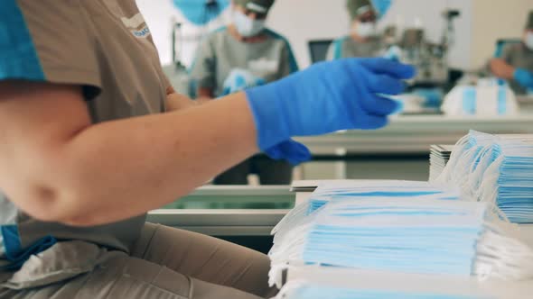 Batches of Face Masks Are Getting Put Together By a Factory Worker