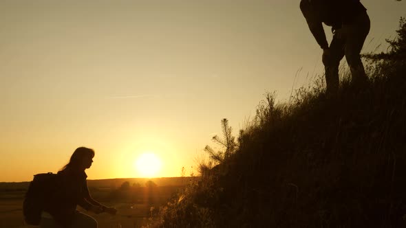 Tourists Climb the Mountain at Sunset, Holding Hands. Teamwork of Business People. Traveler Man