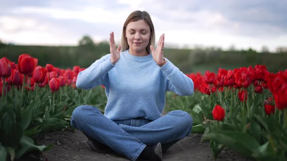 Calm Woman Relaxing Meditating in Tulips Field Alone