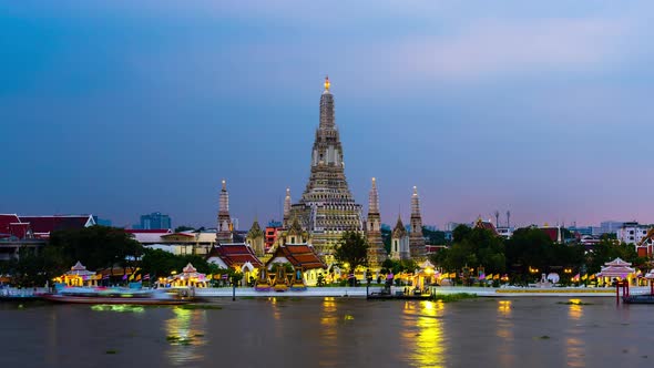 day to night time lapse of Wat Arun Temple with Chao Phraya river in Bangkok, Thailand