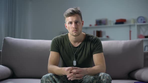 Sad Male Military Sitting on Sofa and Looking at Camera, Psychological Trauma