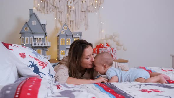 Young Mother Playing with Her Baby on the Bed