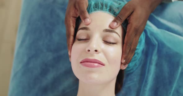 Masseuse Making Head and Face Massage To Her Relaxing and Beautiful Client