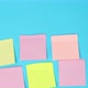 female hand gluing multicolored paper square stickers on a blue surface - VideoHive Item for Sale