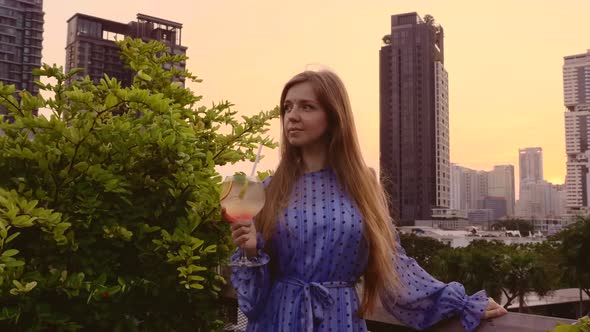 Female in Elegant Dress with Long Hair Relax in Luxury Hotel Skyscrapers View
