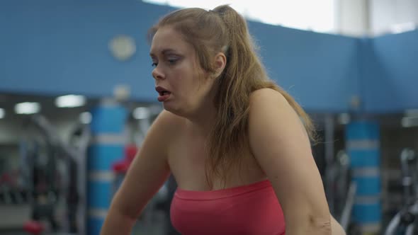 Exhausted Obese Caucasian Woman Sighing Standing in Gym After Training