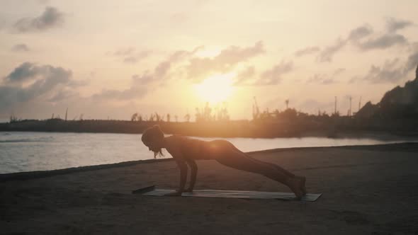 Girl Does Upward Downward Dog Yoga Poses on Mat at Sunrise