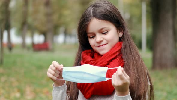 Teenage Girl Put on Protective Mask in a Park