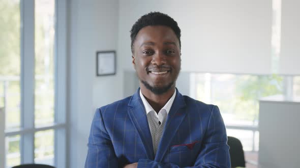 African Successful Businessman Standing in Office with Hands Crossed Looking at Camera