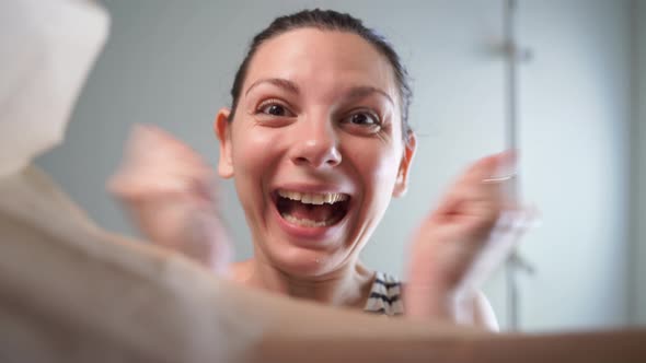 Caucasian Woman Opens Craft Paper Delivery Package with Happy Emotion