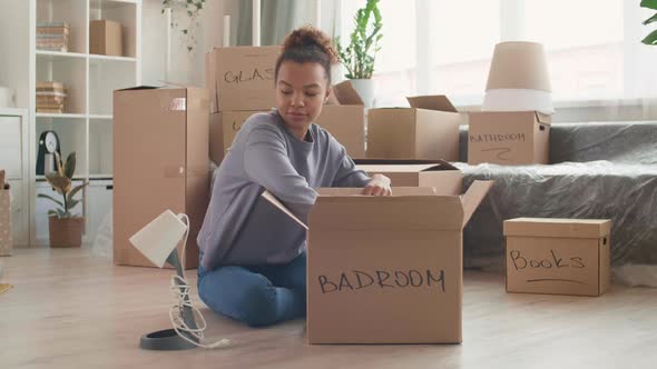 Young Mixed-Race Woman Packing Stuff for Moving