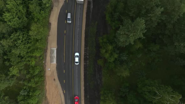 Aerial View of the Highway Going Through the Green Fields and Forests