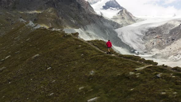 Person runs at a ridge next to Findelglacier, around Zermatt, Switzerland