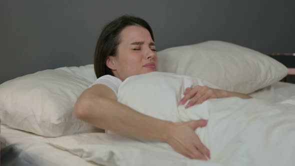 Young Woman with Back Pain Laying in Bed 