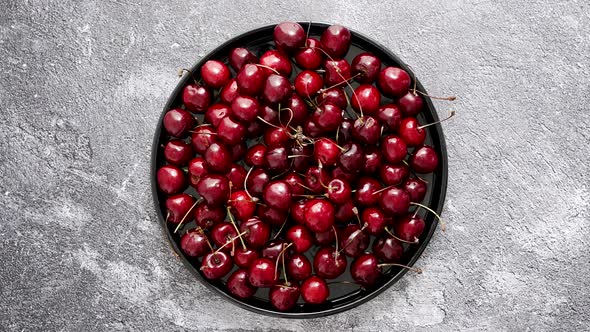 Sweet Fresh Cherry on a Plate on a Stone Background