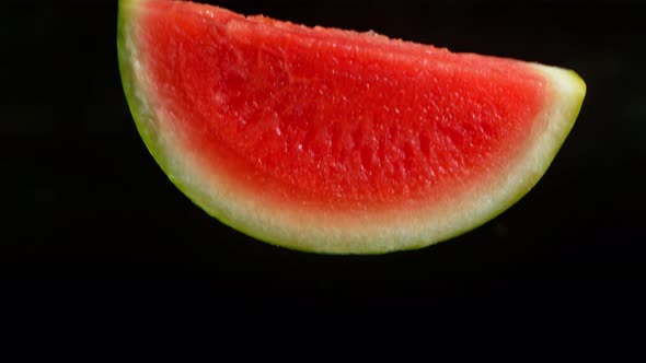 Super Slow Motion Shot of Fresh Melon Slice Falling Into Water Isolated at 1000Fps.