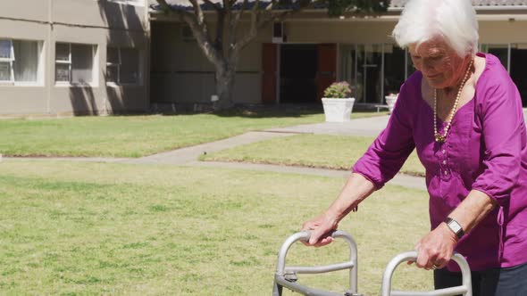 Senior woman walking in the park of a retirement home