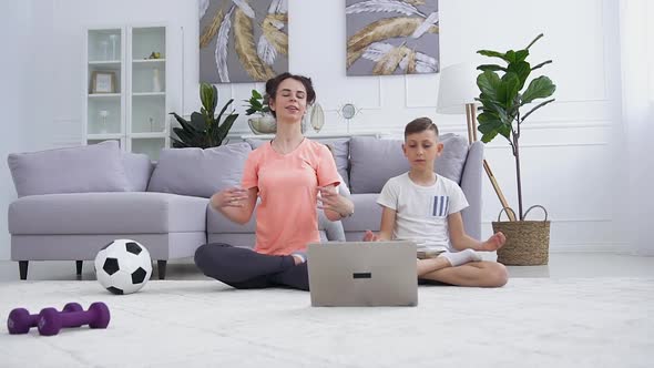 Mother and Her Teen Son Which Doing Together Yoga Relaxing Exercises on the Floor at Home