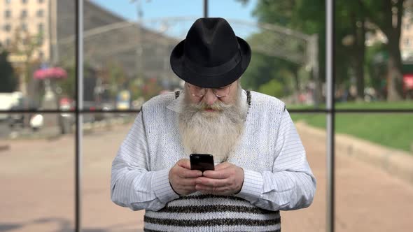 Bearded Pensioner Using His Smartphone