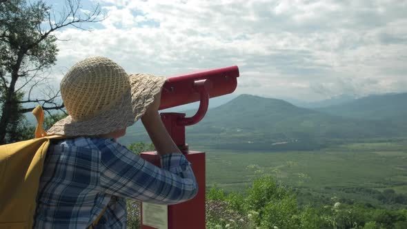 Woman Looking Through Coin Operated Binoculars on Mountains in Vacation Trip