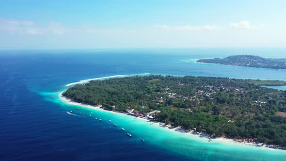 Daytime flying copy space shot of a white paradise beach and blue ocean background in high resolutio