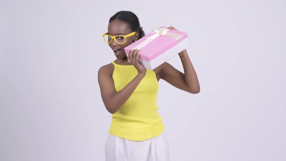 Happy Young Beautiful African Woman Shaking Gift Box