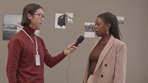 Gallerist Taking Interview of African-American Female Photographer