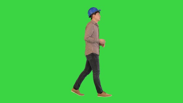 Construction Worker in a Helmet Talking on Camera While Walking on a Green Screen Chroma Key