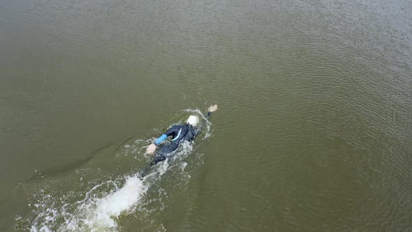 Tracking shot of a female professional swimmer training in lake