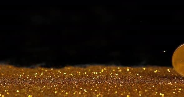 Coin of 1 Euro Rolling on Gold Powder against Black Background, Slow motion 4K