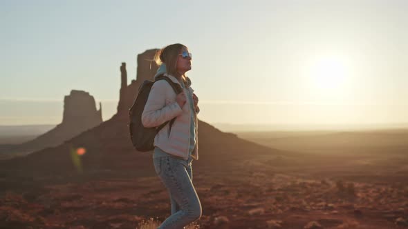 Happy Smiling Woman with Backpack in Red Southwest American Desert at Sunset