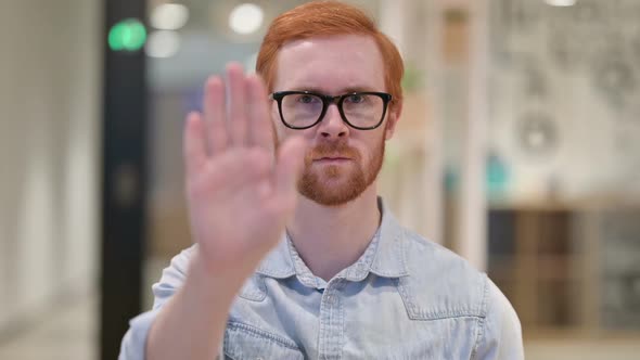 Young Redhead Man Showing Stop Sign By Hand