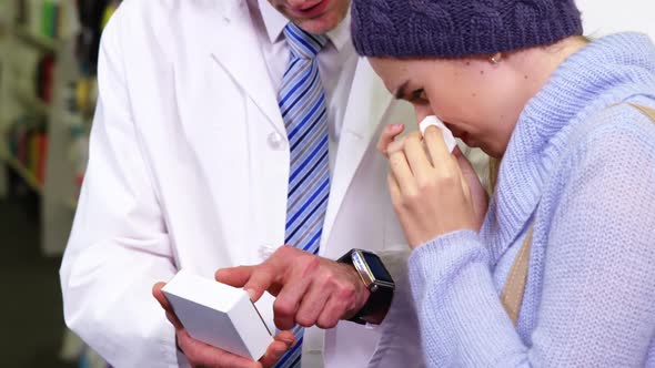 Pharmacist showing medicine to customer